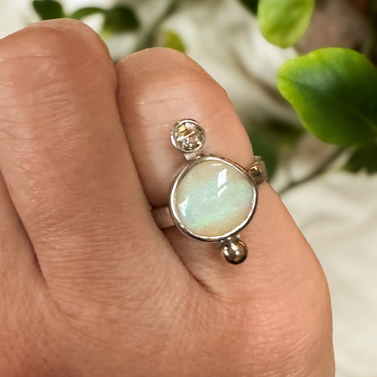 Opal and rutile quartz ring on hand, one of a kind handcrafted Natural Earth Collective Ohio