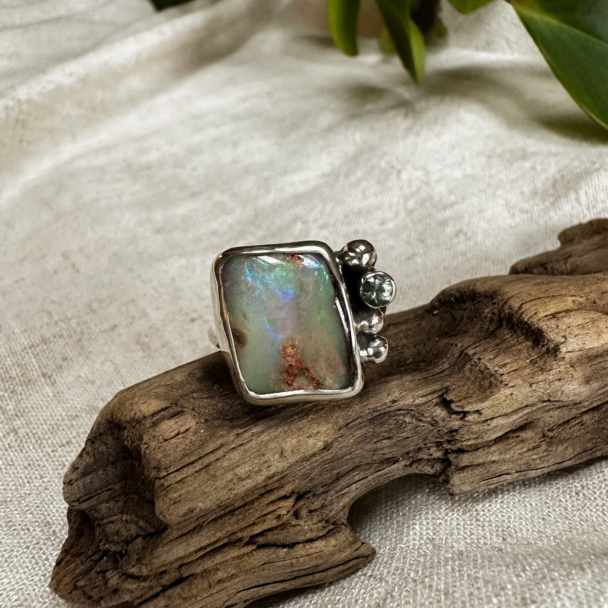 Boulder Opal and olive sapphire ring on hand, one of a kind handcrafted Natural Earth Collective Ohio