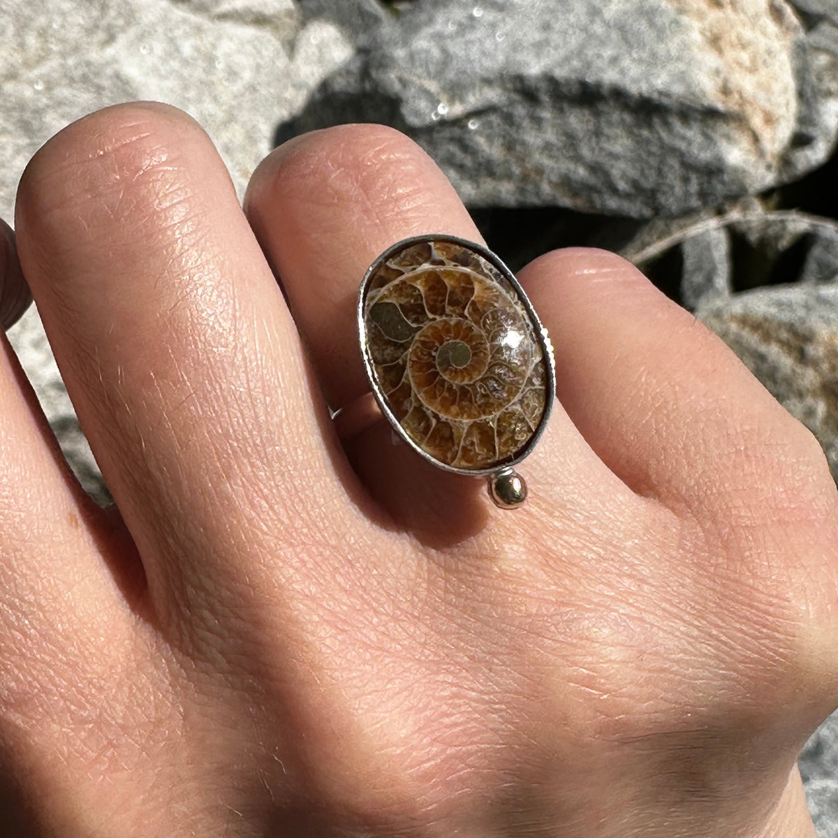 Fossilized ammonite ring on hand, ancient ocean fossil jewelry Natural Earth Collective Ohio